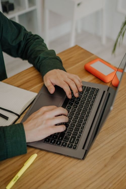 Hands typing on a laptop keyboard